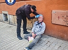 Pomoc zraněnému muži na chodníku